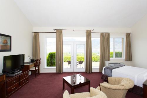 a hotel room with a bed and a television at Shiraz Villa in Osoyoos