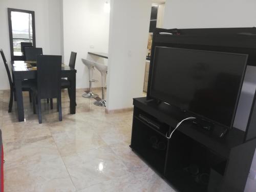 a living room with a television and a table with chairs at Reserva del Peñon in Girardot