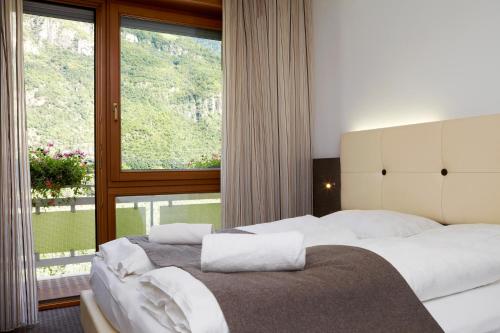 a bedroom with a bed with a large window at Hotel Raffl in Bolzano