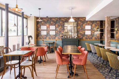 un restaurant avec des tables et des chaises et un bar dans l'établissement Hôtel Littéraire Arthur Rimbaud, BW Signature Collection, à Paris