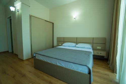a bedroom with a large bed with blue pillows at Twins in Anaklia