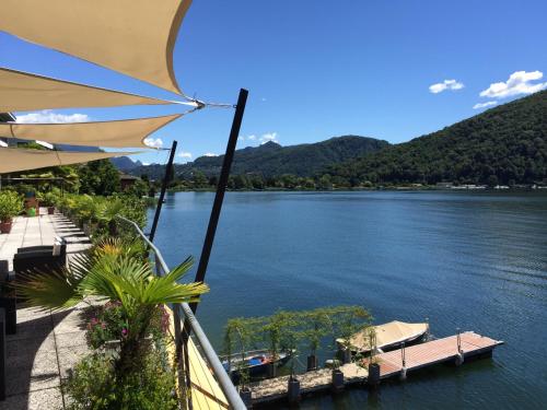 a view of a lake from a balcony with an umbrella at Tresa Bay Hotel in Ponte Tresa