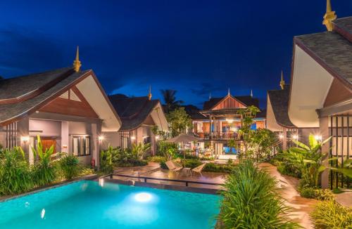 a villa with a swimming pool at night at The Scene Cliff View Villas in Ao Nang Beach