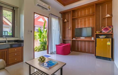 a living room with a tv and a table at The Scene Cliff View Villas in Ao Nang Beach
