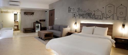 a bedroom with a large bed and a living room at Stark Boutique Hotel and Spa in Kuta