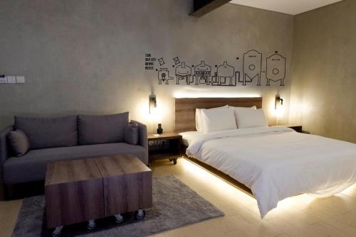 Stark Boutique Hotel and Spa في كوتا: غرفة نوم بسرير واريكة