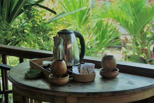a coffee pot sitting on top of a table at Dream Beach Inn in Nusa Lembongan