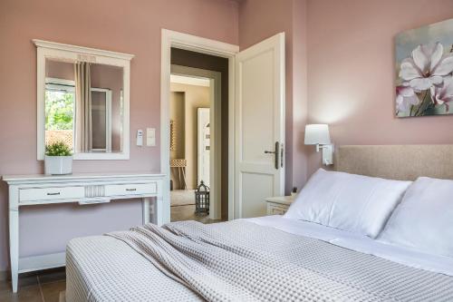 a bedroom with a bed and a table and a mirror at Julia's Villa style Apartment in Kástron