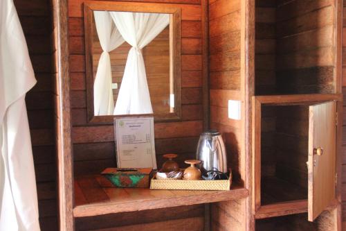 a shelf in a wooden cabin with a mirror at Dream Beach Inn in Nusa Lembongan