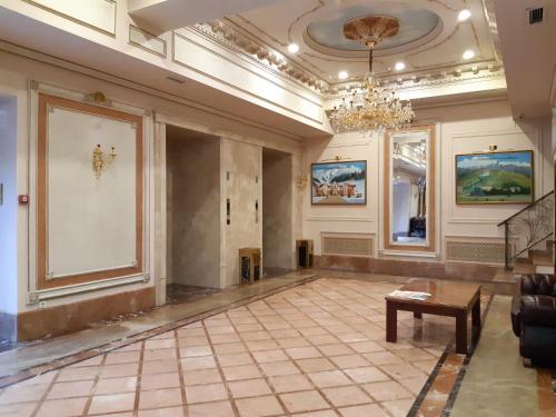 a living room filled with furniture and a painting on the wall at Grand Hotel Eurasia in Almaty