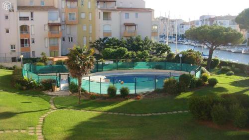 une image d'une piscine en face d'un bâtiment dans l'établissement PORT RAPHAEL, au Cap d'Agde