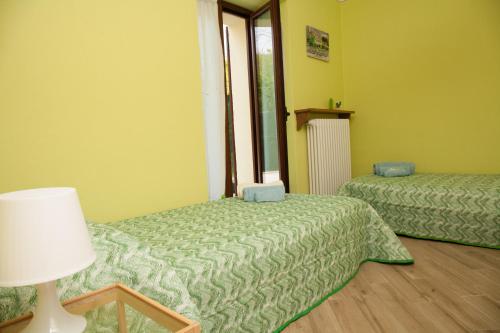 Pokój z 2 łóżkami, lampką i oknem w obiekcie casa margherita w mieście Borgo San Dalmazzo