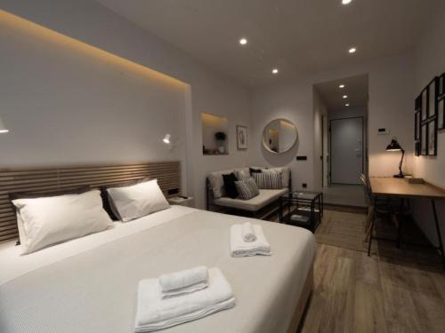 a bedroom with a large white bed and a living room at Downtown Syntagma apartment 2 in Athens