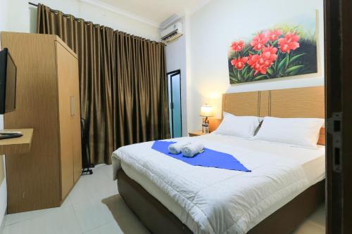 a bedroom with a bed with a stuffed animal on it at Labuana Homestay & Cafe Garden in Makassar