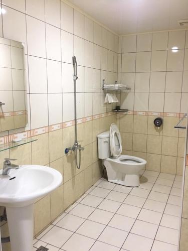 La salle de bains est pourvue de toilettes et d'un lavabo. dans l'établissement Rural Area Hotel, à Wanqiao