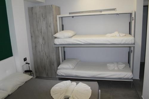 two bunk beds in a room with white sheets at Olive Luxury Rooms in Ýpsos