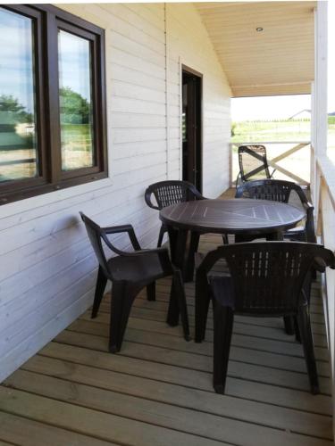 a patio with a table and chairs on a porch at Domek nad morzem in Będzino