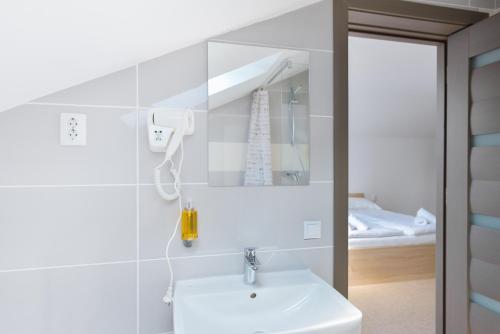een badkamer met een witte wastafel en een spiegel bij Pension Verona Centru in Cluj-Napoca