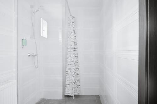 a white bathroom with a shower with a glass curtain at Pension Verona Centru in Cluj-Napoca