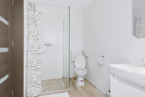 a white bathroom with a toilet and a shower at Pension Verona Centru in Cluj-Napoca