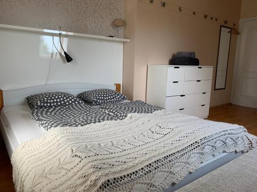 a bedroom with a white bed and a white dresser at Beltes Street Guest House in Jūrmala