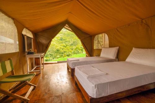 a bedroom with two beds in a tent at Wild Glamping Knuckles - Thema Collection in Rangala