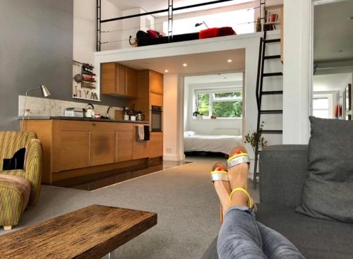 a person laying on a couch in a living room at Lovely New York style flat in Greenwich - Blackheath in London