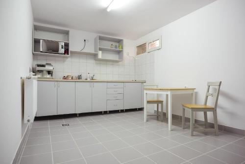 a kitchen with white cabinets and a table and a microwave at Casa Verona Centru in Cluj-Napoca