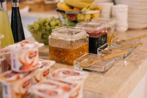 a counter topped with jars of food and grapes at Boulevard Hotel Batumi in Batumi
