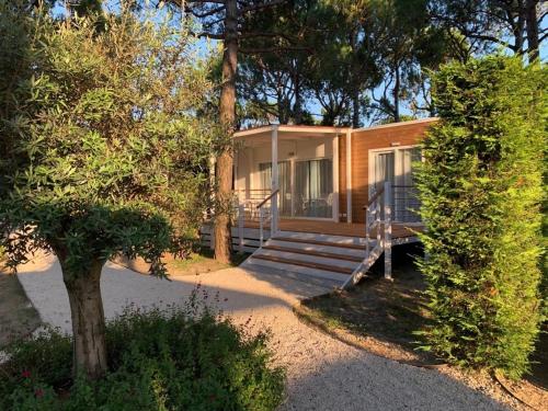 a home with a porch and stairs to a house at Dune Prestige & Chalets in Bibione