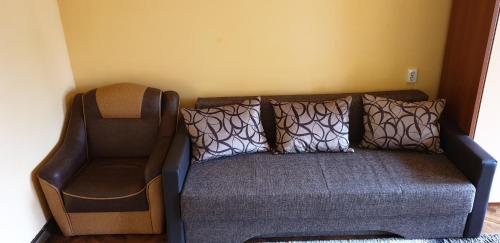 a couch and a chair in a room at Citadel Park Apartment in Sighişoara