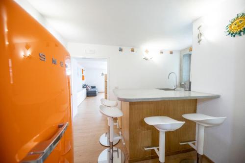 a kitchen with a sink and a counter with stools at La suite di Ruggero in Cefalù