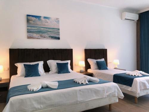 two beds in a bedroom with blue and white at Vila Navona in Saturn