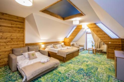 a living room with two couches and a skylight at Gold Hotel in Zakopane