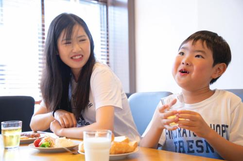 a woman and a boy sitting at a table eating food at Narita AIC Airport Hotel in Narita