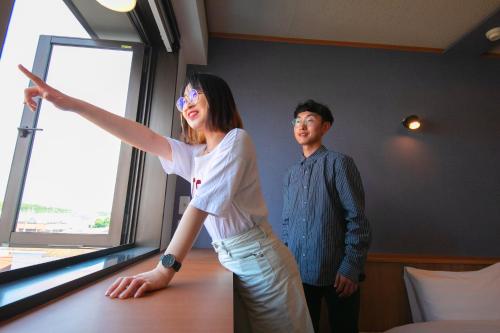 a man and a woman standing next to a window at Narita AIC Airport Hotel in Narita