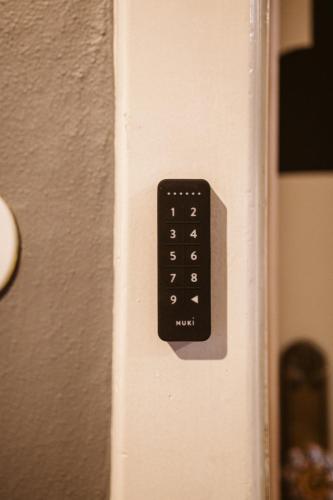 a black remote control on the side of a refrigerator at The Keep Eco Rooms in Salzburg
