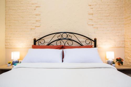 1 dormitorio con 1 cama con sábanas blancas y almohadas rojas en Best Place near Lviv Polytechnic, en Leópolis