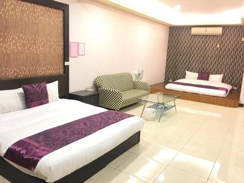- une chambre avec un lit, un canapé et une chaise dans l'établissement Rural Area Hotel, à Wanqiao