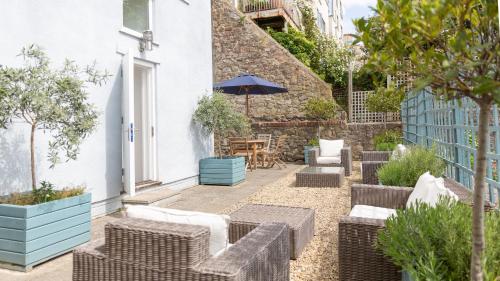 a patio with wicker chairs and a table with an umbrella at Number 38 Clifton in Bristol