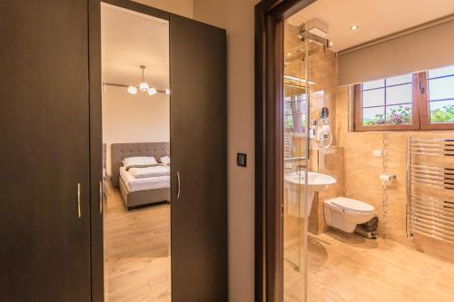 a bathroom with a glass door leading to a bedroom at Pension Kokel in Dumbrăveni