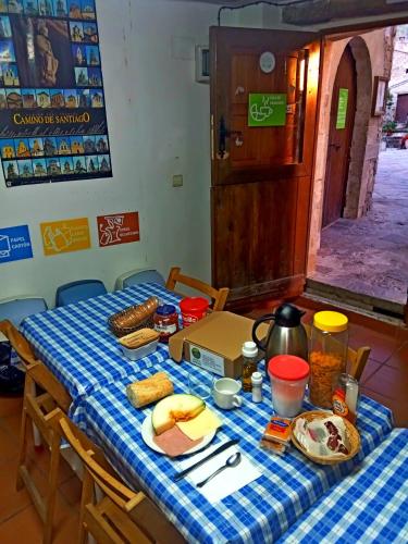 a table with a blue checked table cloth and food on it at Albergue Restaurante de Artieda in Artieda