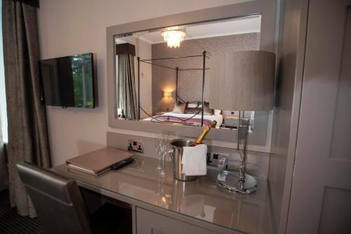 a desk with a mirror and a lamp on it at Cubley Hall in Penistone