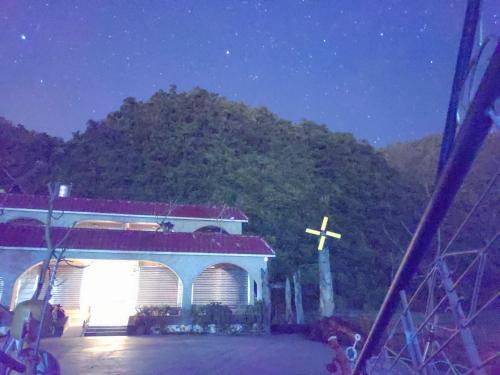 a church with a cross in front of a mountain at Lutenist B&B in Yuanshan