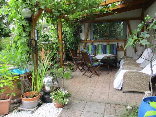an outdoor patio with chairs and tables and plants at Ferienwohnung Wendel in Erbach im Odenwald
