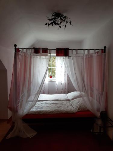 a bedroom with a bed with a window at Romantik Ferienwohnung am Tor zum Allgäu in Fuchstal