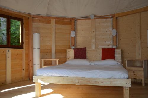 a bedroom with a bed in a wooden room at Camping Du Parc in Pré-Saint-Didier
