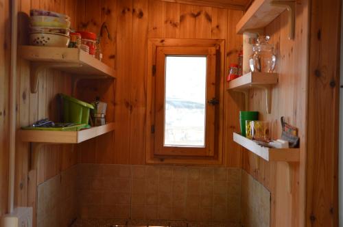 a bathroom with wooden walls and a window and shelves at Camping Du Parc in Pré-Saint-Didier