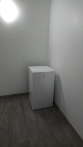 a small white cabinet in a corner of a room at Le patio d'olivier in Lalinde