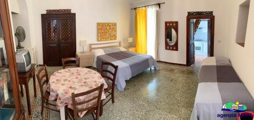1 Schlafzimmer mit 2 Betten, einem TV und einem Tisch in der Unterkunft Magi - Appartamento Mimosa in Ponza